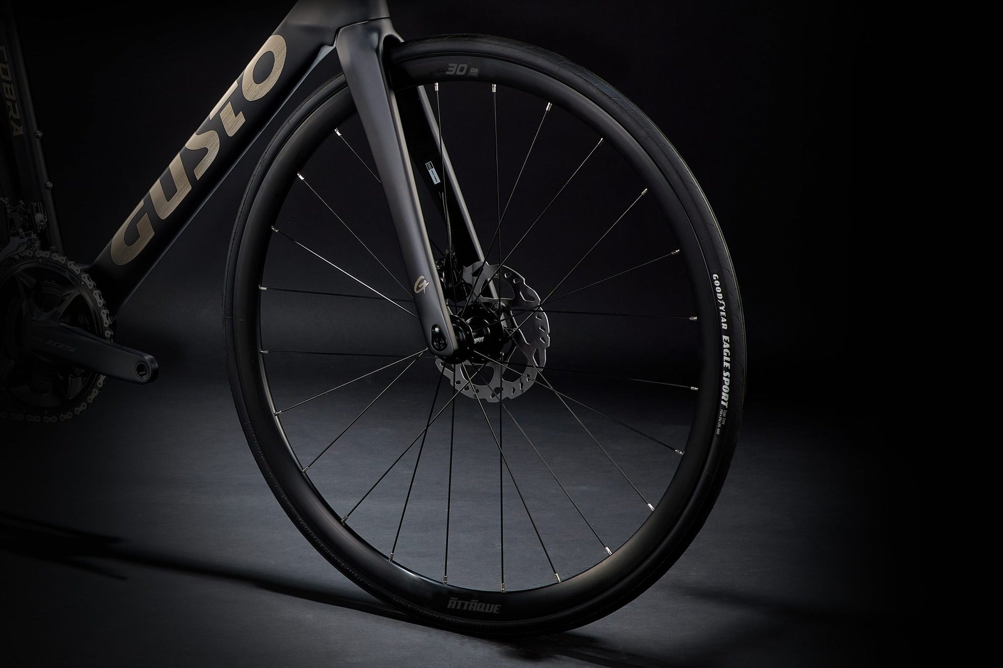 Close-up of a bicycle wheel with 'Custo' branding on a dark background