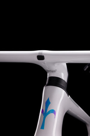 Close-up of a white bicycle frame with a logo on a black background